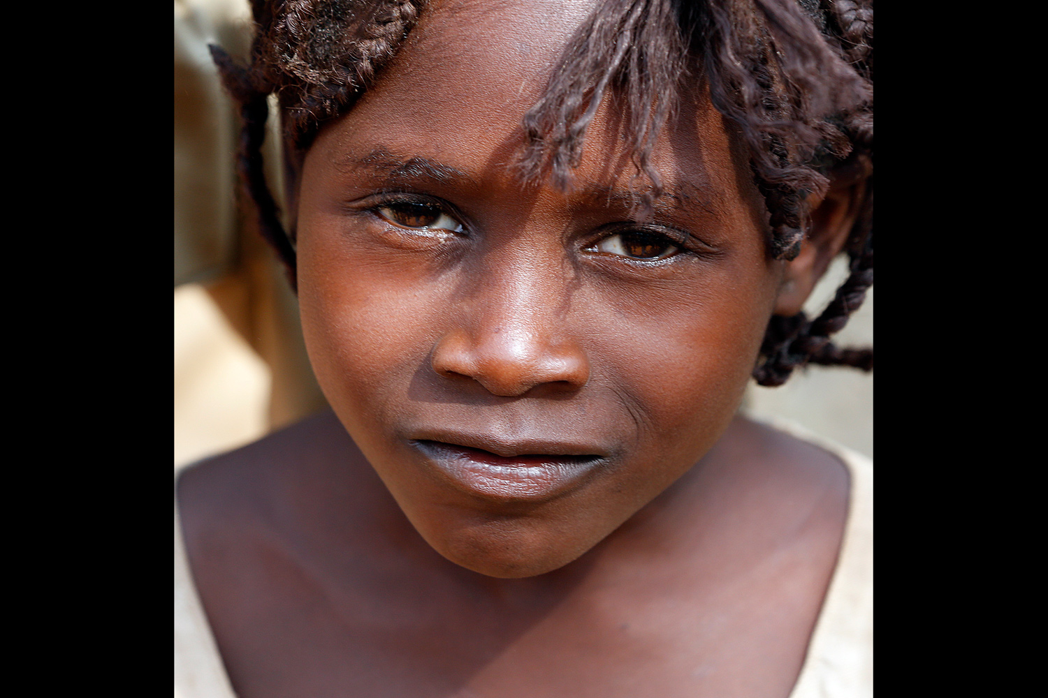 Portrait d’une écolière au regard complice au Bénin en 2013