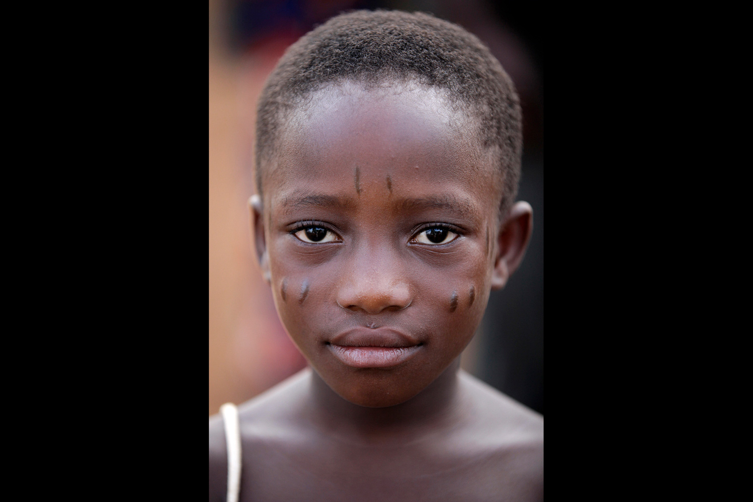 Portrait d’une fillette portant des scarifications traditionnelles au Bénin en 2011