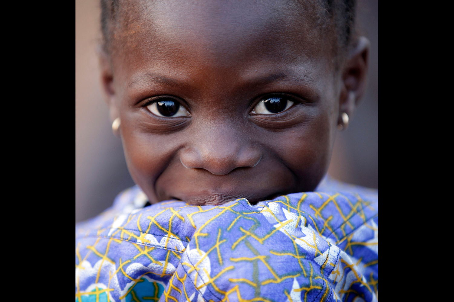 Portrait d’une jeune fille au regard complice au Bénin en 2011
