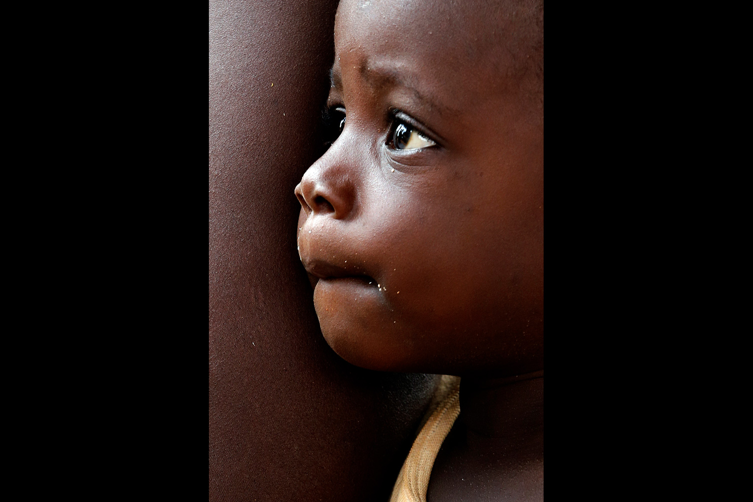 Portrait d’un jeune garçon au regard captivé au Bénin en 2013