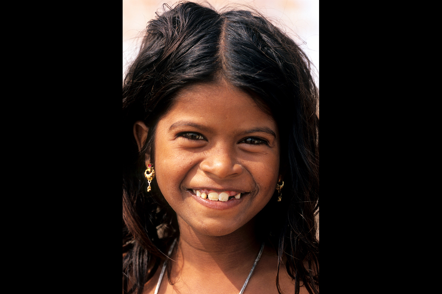 Fillette souriante sur les bords du Gange à Bénarès en Inde en 2005