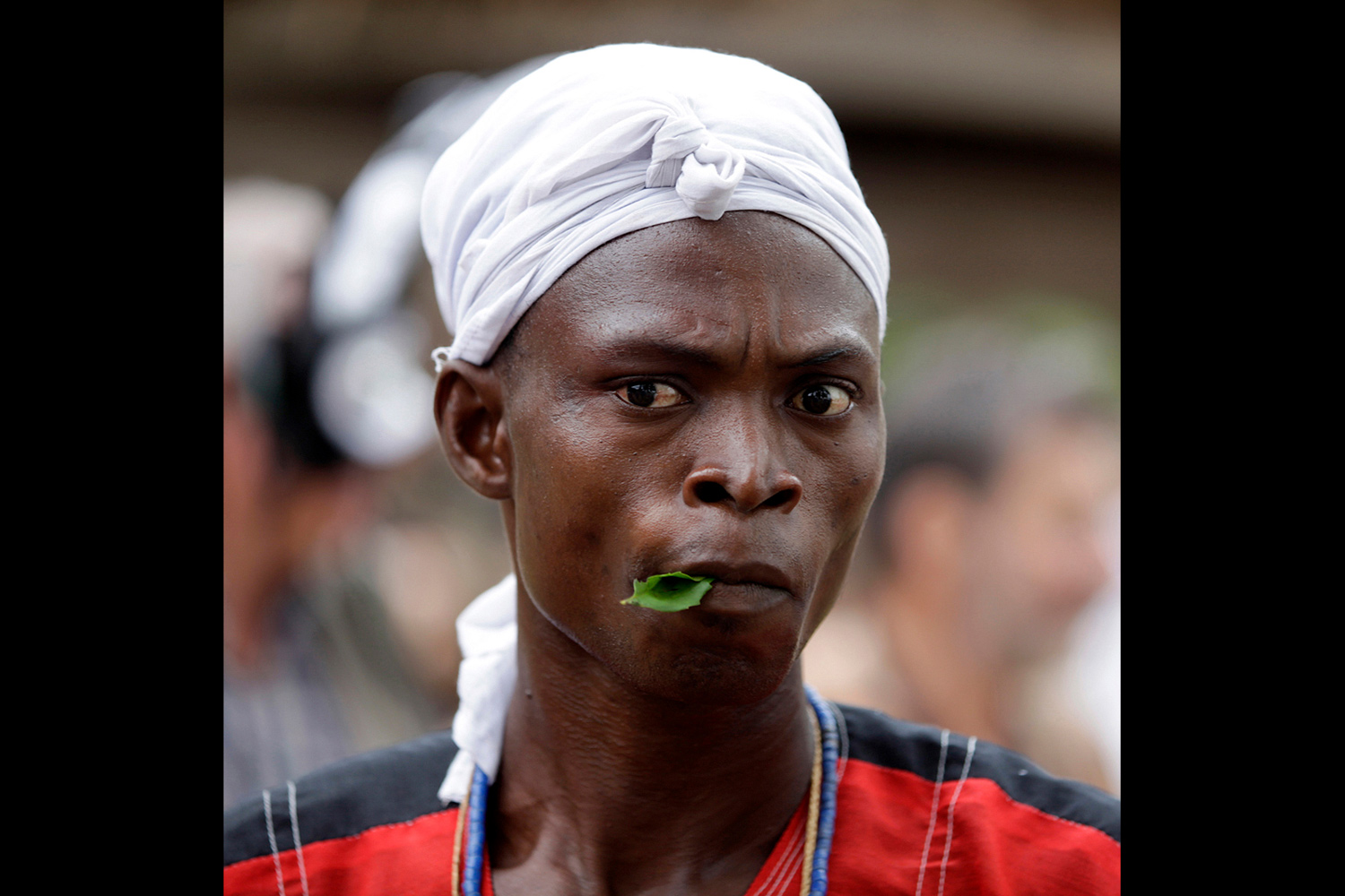 Homme initié tenant une feuille dans la bouche au Bénin en 2011