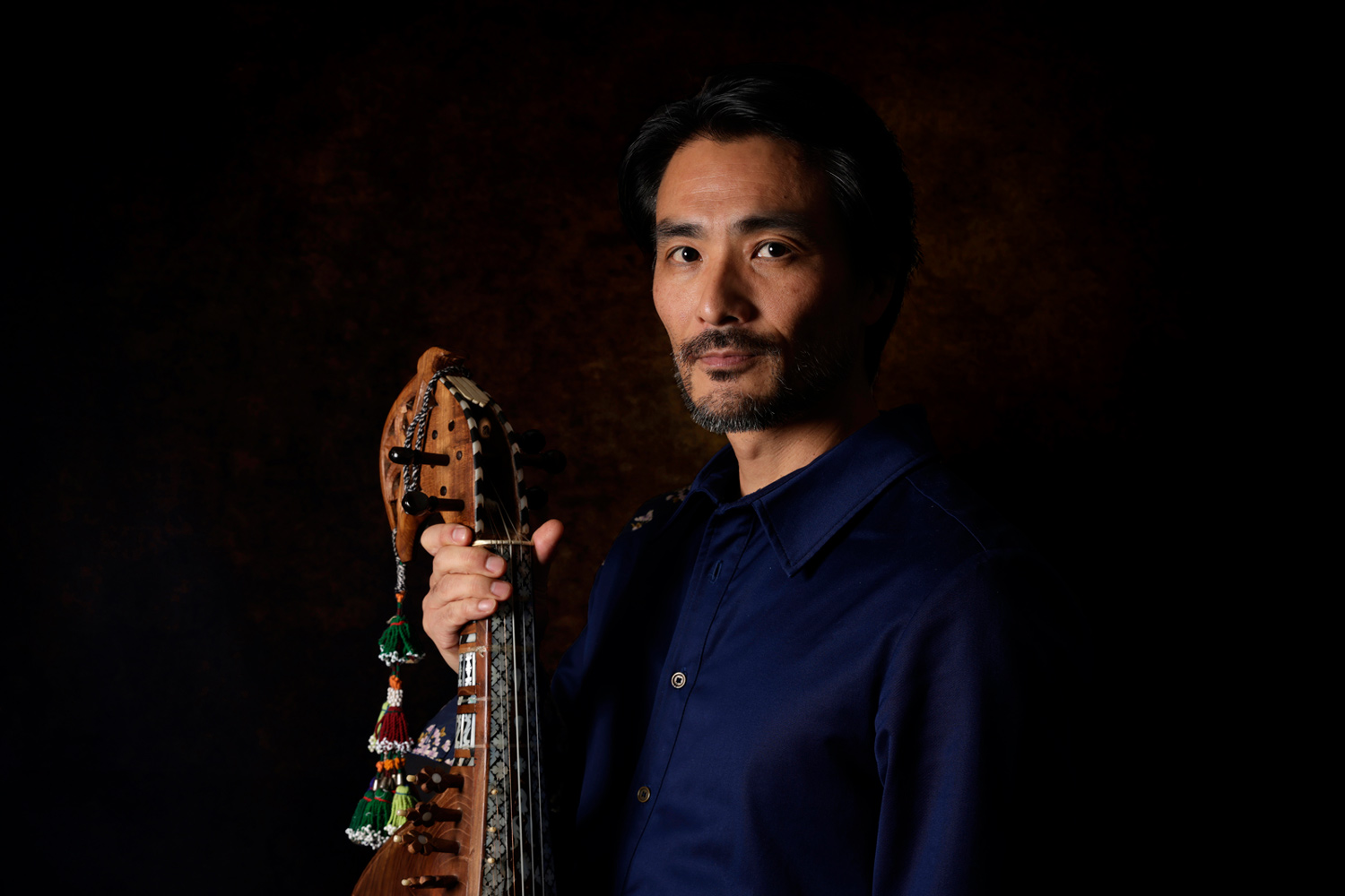 Kengo Saito tenant un rubâb afghan lors d’un shooting en 2024 pour le Japanistan Trio