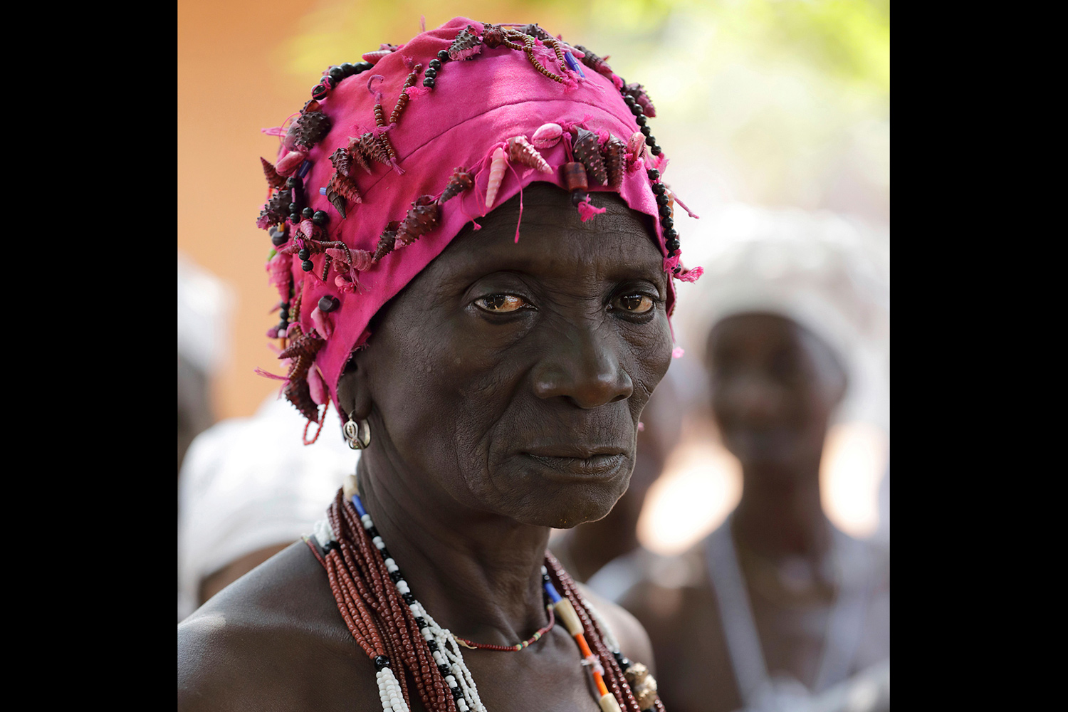 Prêtresse du culte Sakpata au Bénin en 2017 portant un bonnet orné de coquillages