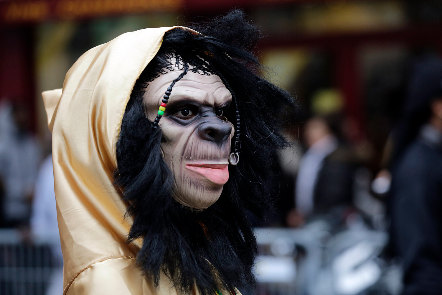 Personnage portant un masque de gorille et une cape dorée lors du Carnaval Tropical de Paris.
