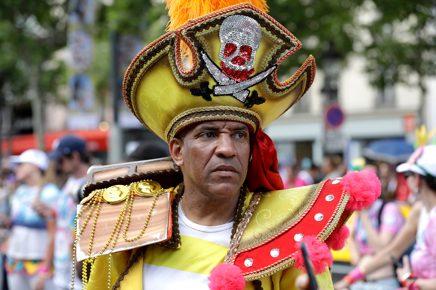 Portrait d'un participant portant un costume jaune et rouge avec une haute coiffe ornée d'une tête de mort.
