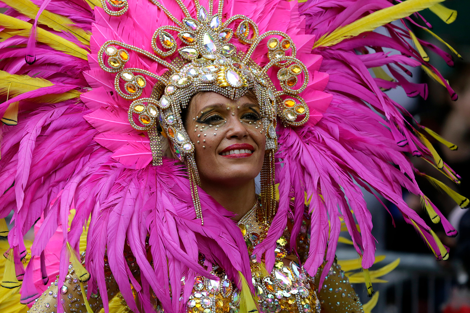 Danseuse portant une spectaculaire coiffe rose composée de plumes et de bijoux.
