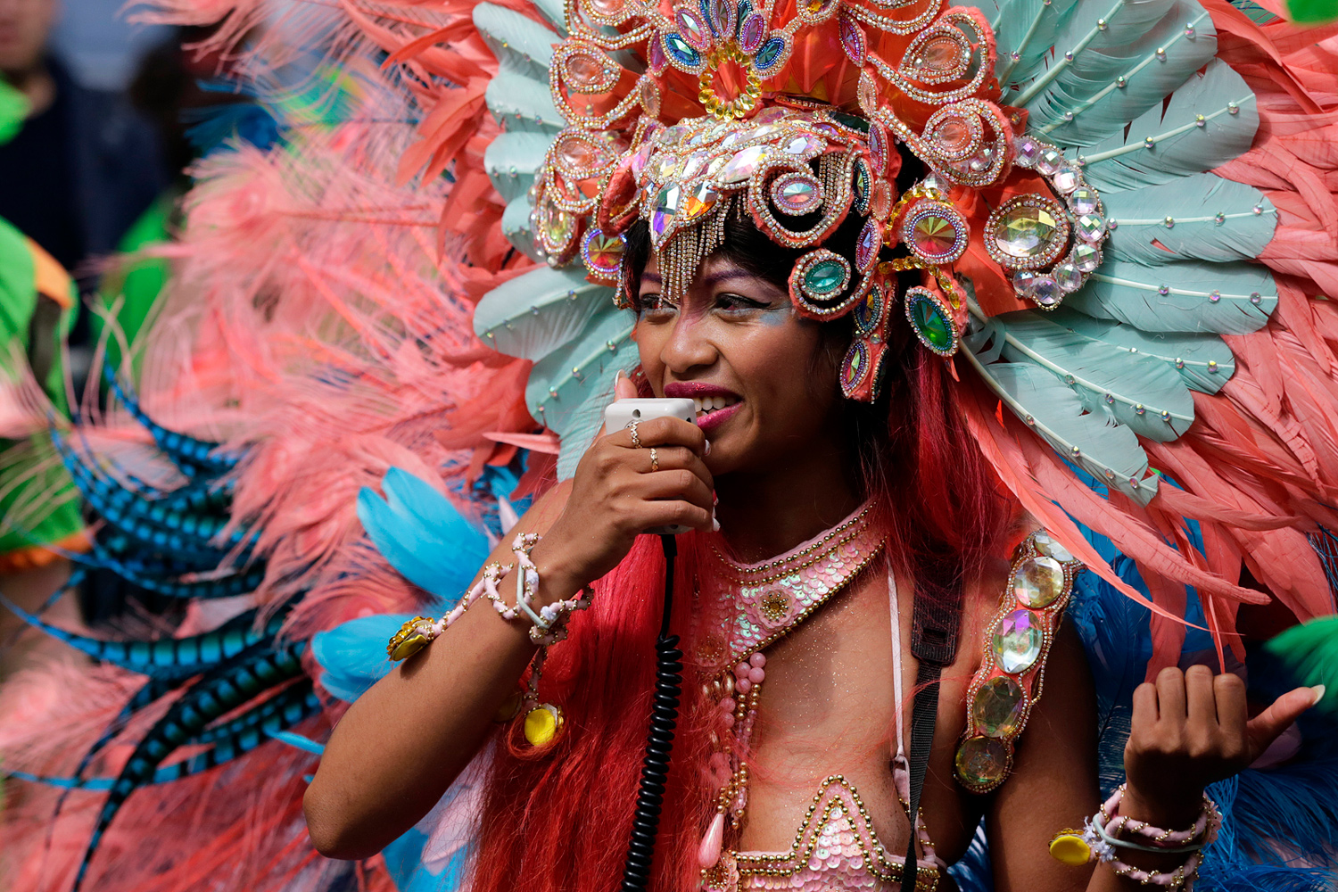 Danseuse portant un costume rose orné de plumes et de bijoux.