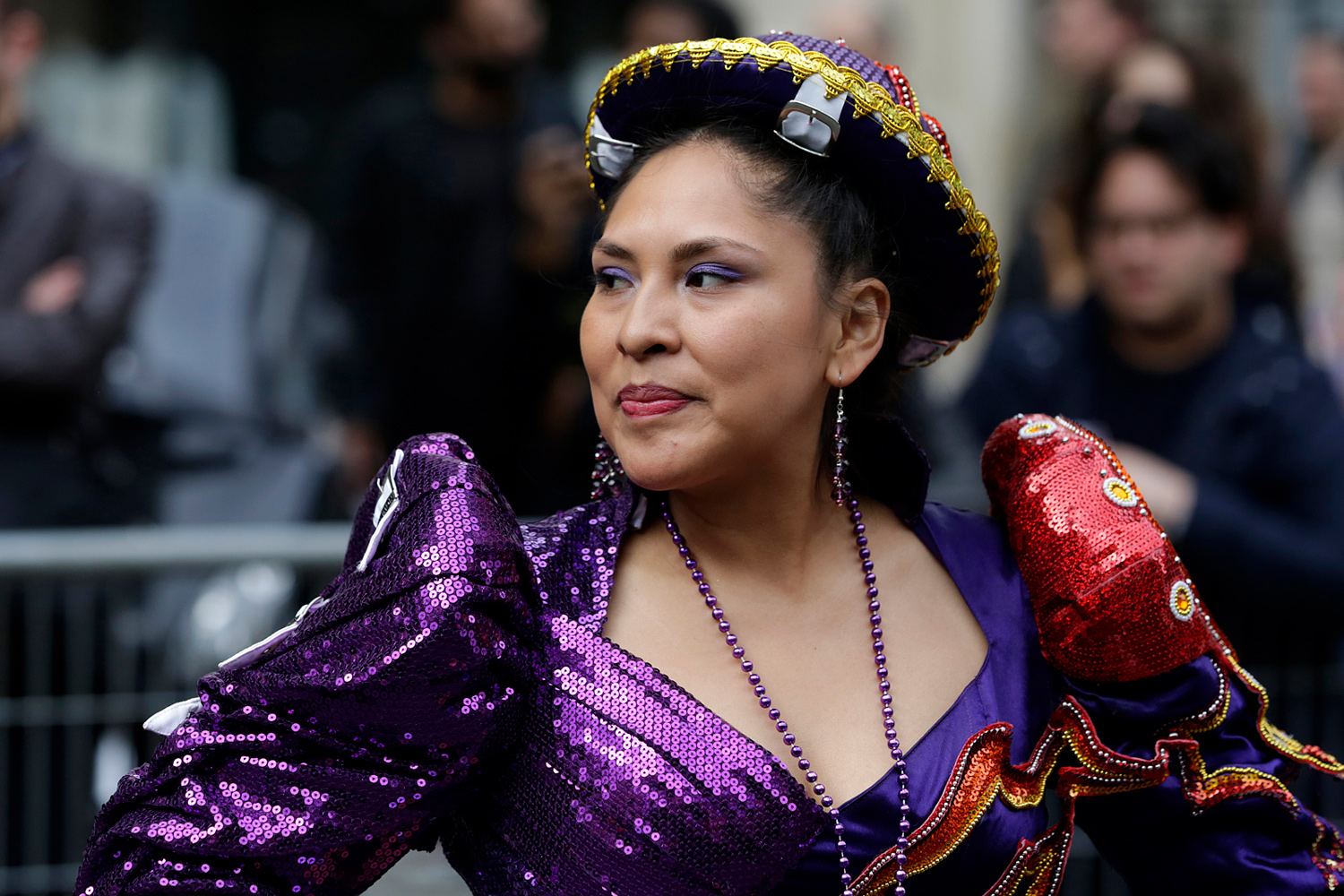 Danseuse vêtue d'un costume violet traditionnel participant au défilé.