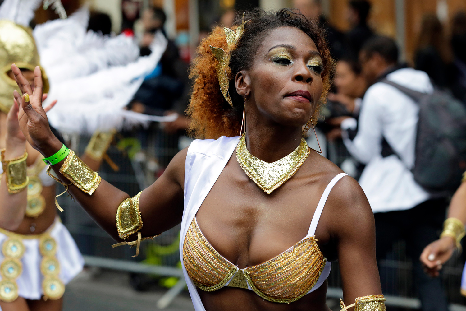 Danseuse en costume doré portant un soutien-gorge orné de perles et de bijoux lors du Carnaval Tropical de Paris 2016.