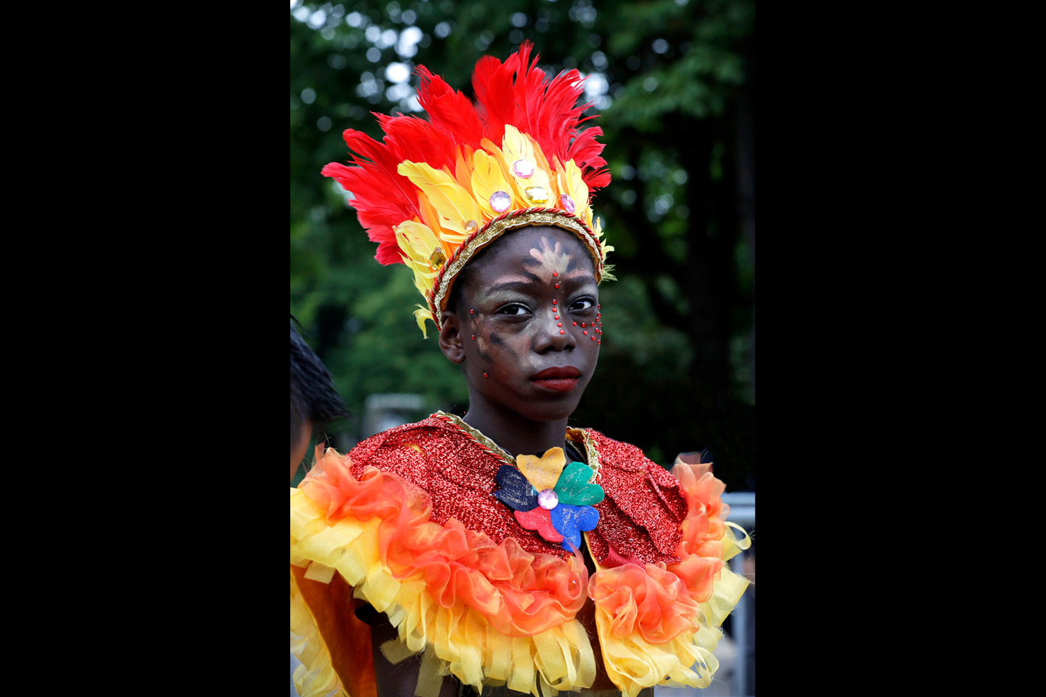 Portrait d'un enfant portant un costume rouge, orange et jaune inspiré des flammes.