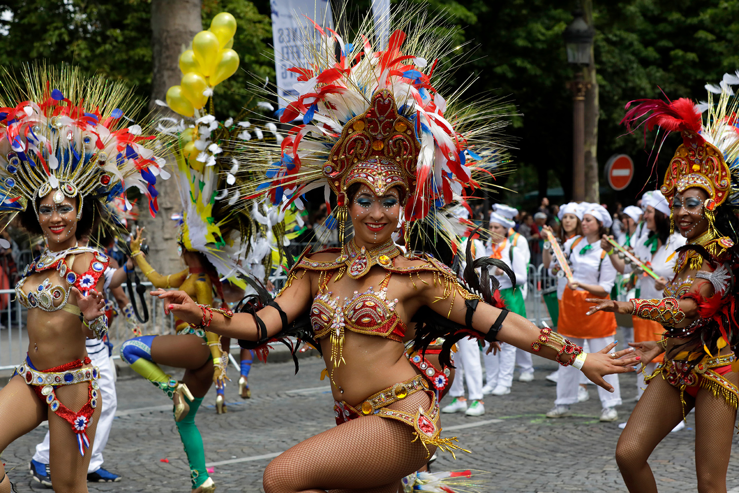 Danseuses exécutant une chorégraphie dans des costumes rouges et dorés richement décorés.