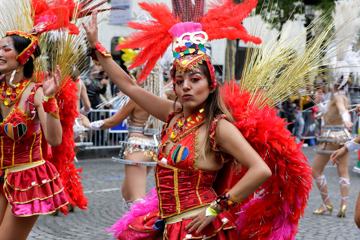 Danseuse en costume rouge exécutant une chorégraphie au sein de son groupe.