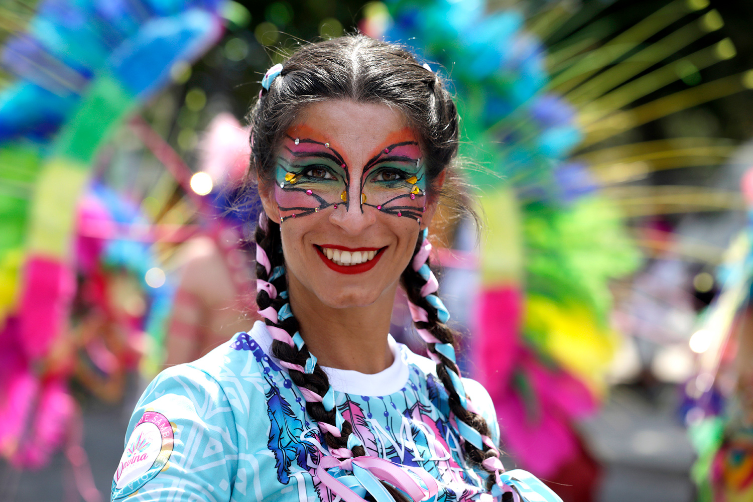 Portrait d'une participante souriante au maquillage inspiré des ailes de papillon.