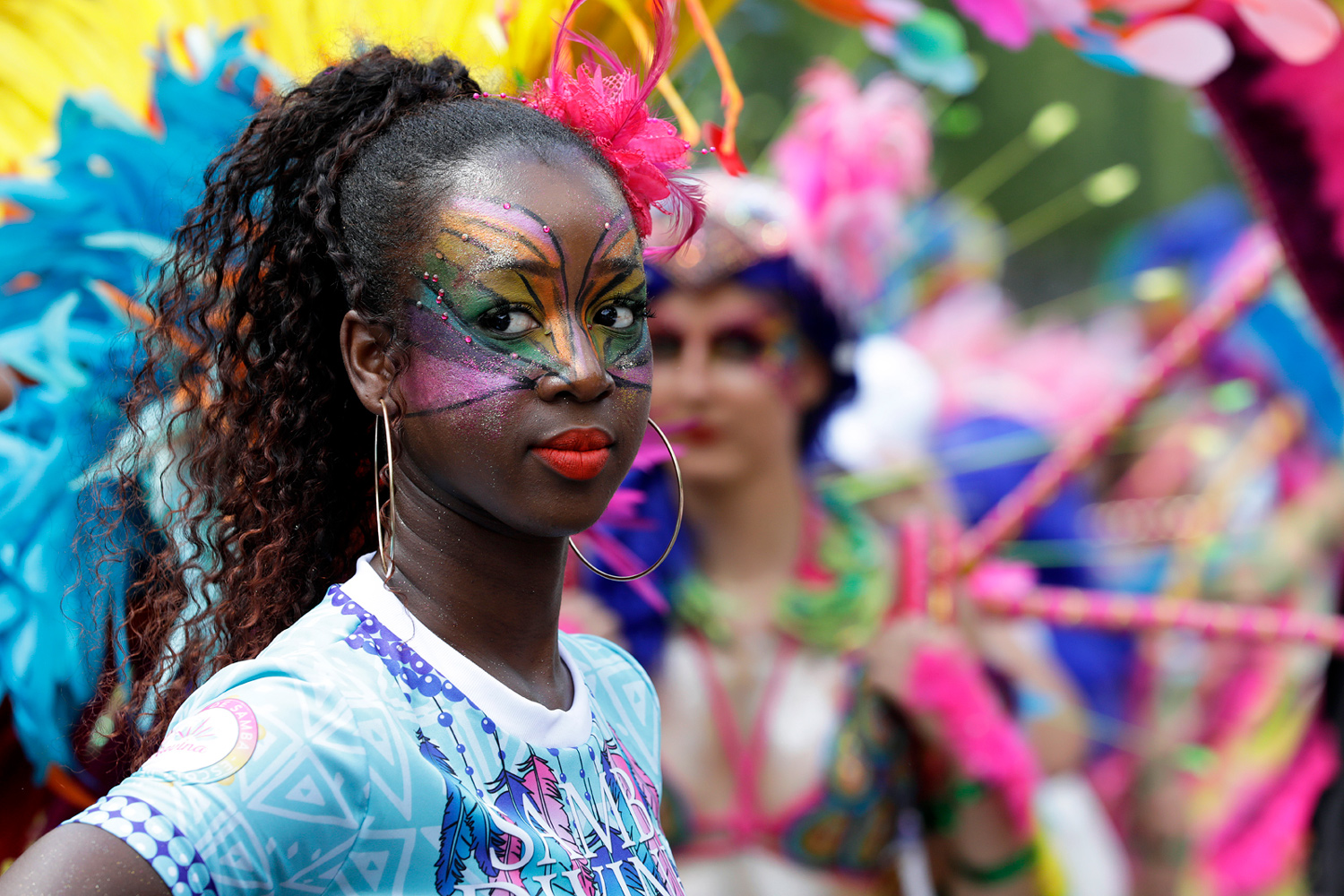 Portrait d'une participante portant un maquillage artistique multicolore et un tee-shirt aux couleurs du groupe.