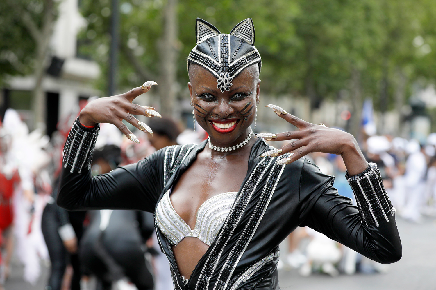 Portrait d'une danseuse vêtue d'un costume noir et argent, effectuant une pose expressive devant le public.